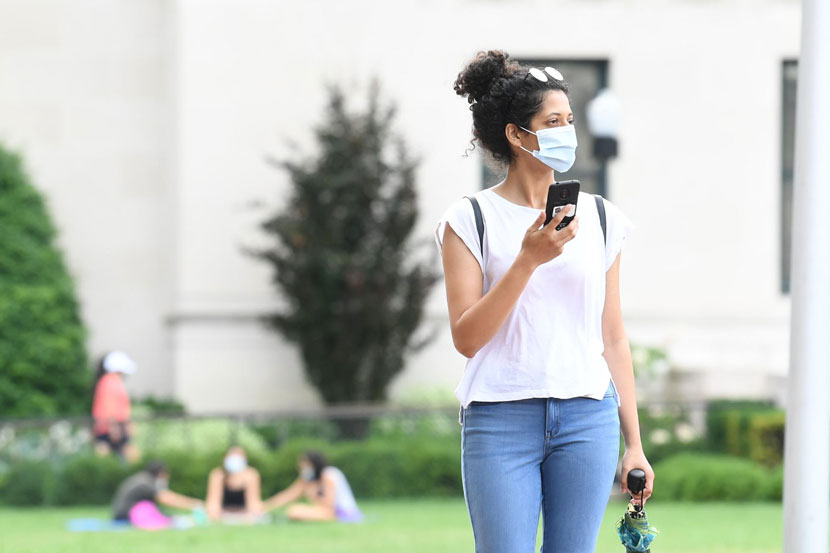 A student crosses the Columbia University campus wearing a face mask